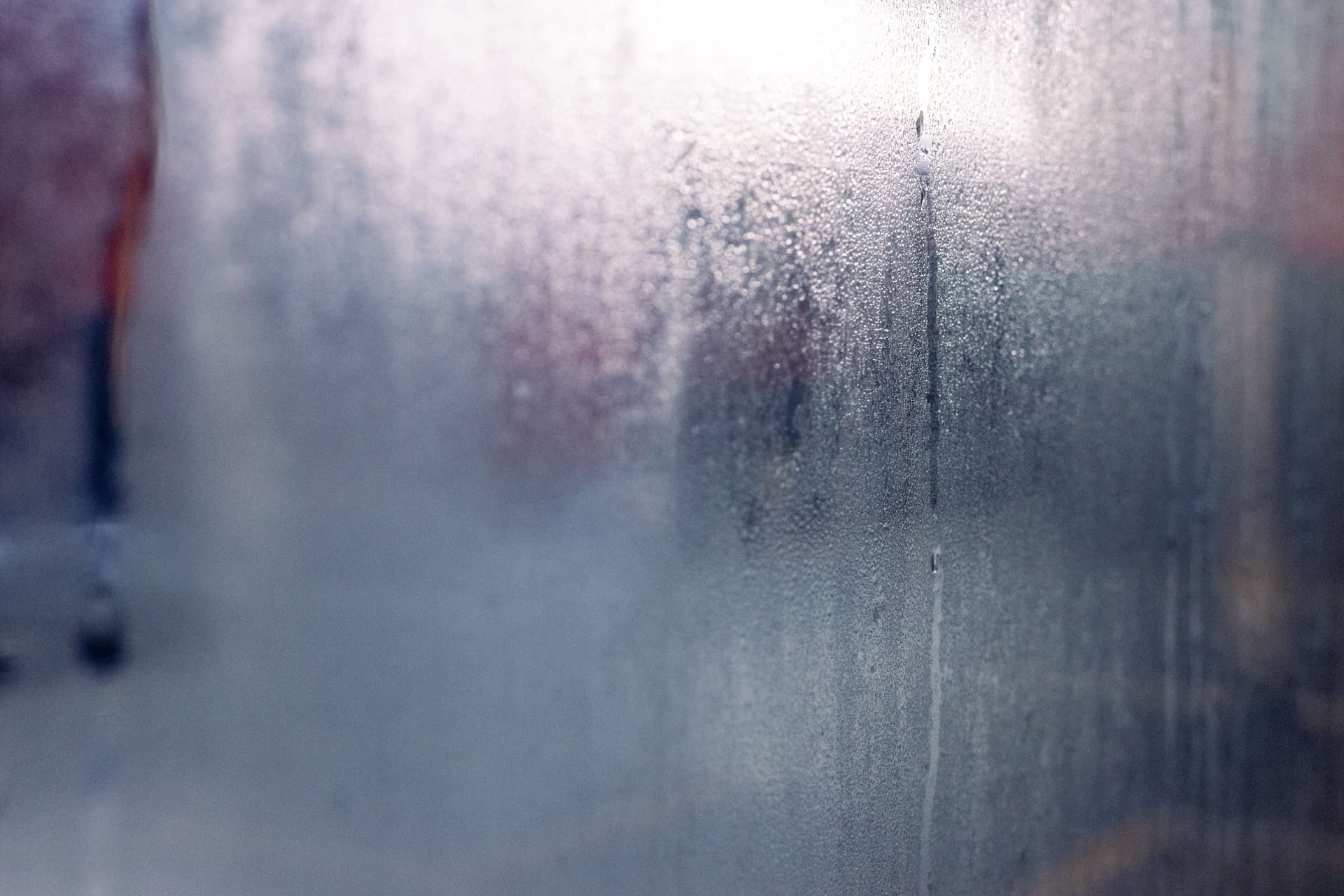 Close-up of droplets and mist on a fogged window pane
